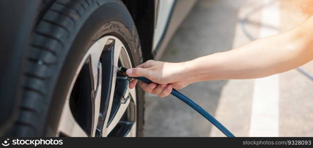 hand inflating tires of vehicle, checking air pressure and filling air on car wheel at gas station. self service, maintenance and safety transportation concept