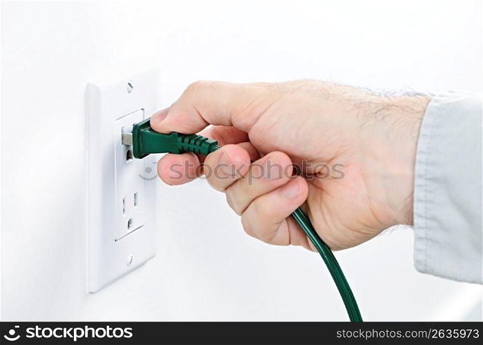Hand inserting plug into outlet