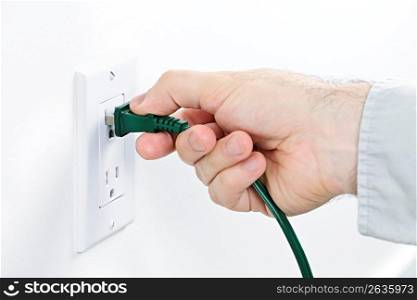 Hand inserting plug into outlet