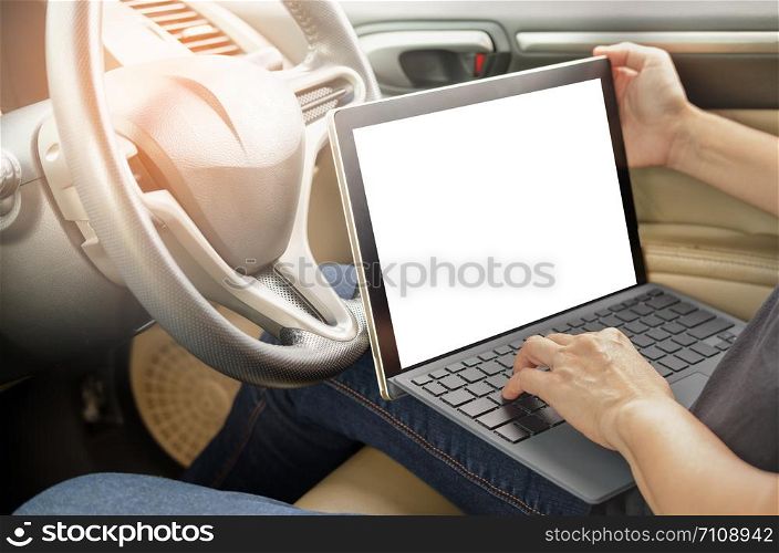 Hand is holding a touch labtop with isolated screen in the car.