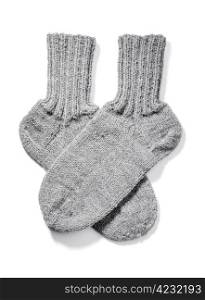 Hand-knitted warm wool socks isolated on white with natural shadows.