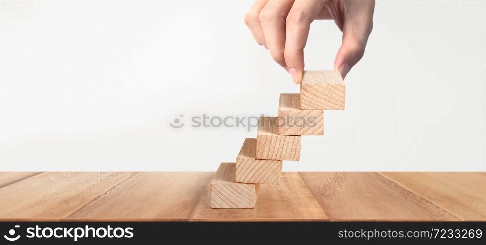 Hand liken person stepping up a toy staircase wood