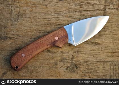 Hand made hunting knife on wooden background