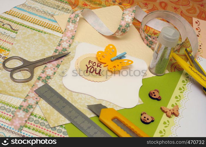 hand made scrapbooking post card and tools lying on a table