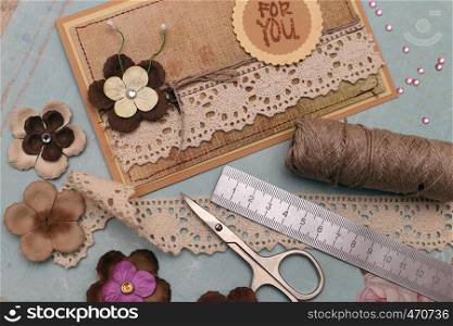 hand made scrapbooking post card and tools lying on a table