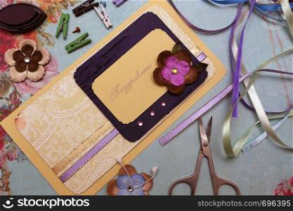hand made scrapbooking post card and tools lying on a table