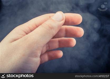 Hand making a gesture on a black smoky background