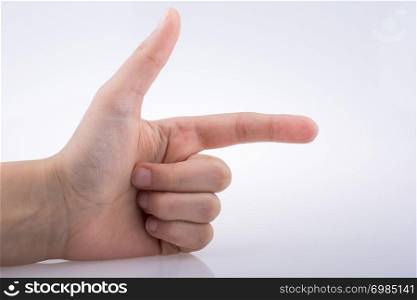 Hand making a gun gesture on a white background