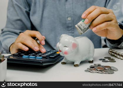 Hand man person holding dollar and calculator saving in pig bank. business finance economy investment tax accounting money and coin deposit concept.