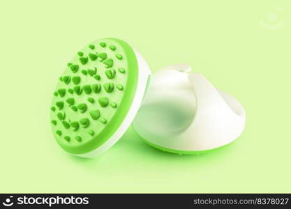 Hand massager with silicone spikes for anti-cellulite massage procedure isolated on green background. Massage brush tool for problem body zone, self-care, health care, body therapy.. Hand massager with silicone spikes for anti-cellulite massage isolated on green background.