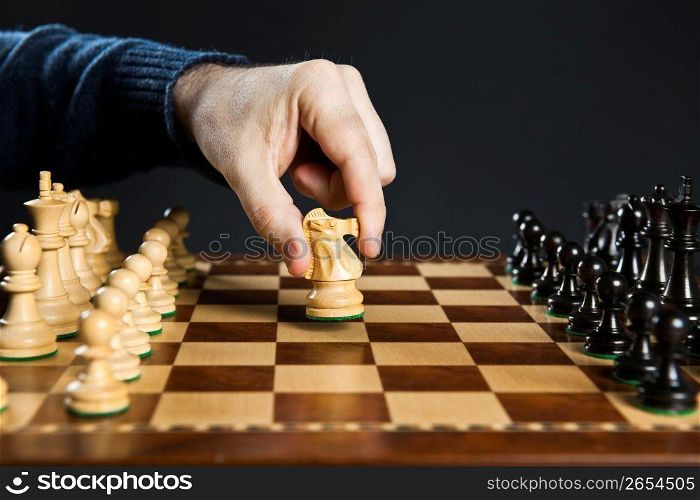 Hand moving knight on chess board
