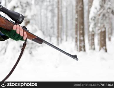 Hand of a Hunter, holding a rifle in a winter forest