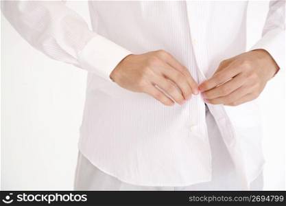 Hand of a man fastening the button of the shirt