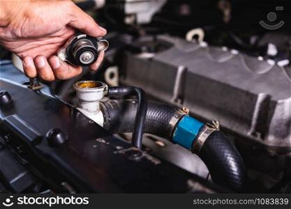 Hand of auto mechanic technician service check cooling water he open radiator cap the in garage