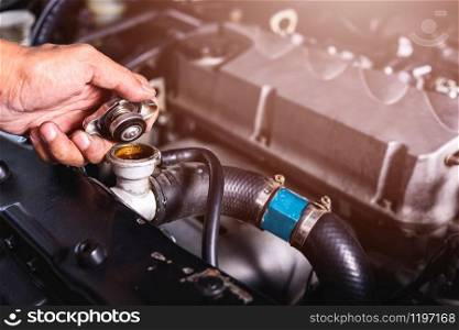 Hand of auto mechanic technician service check cooling water he open radiator cap the in garage