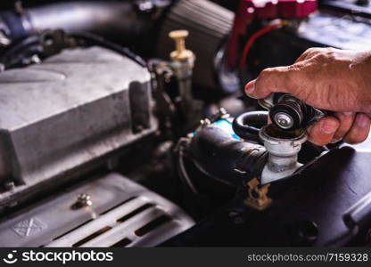 Hand of auto mechanic technician service check cooling water he open radiator cap the in garage