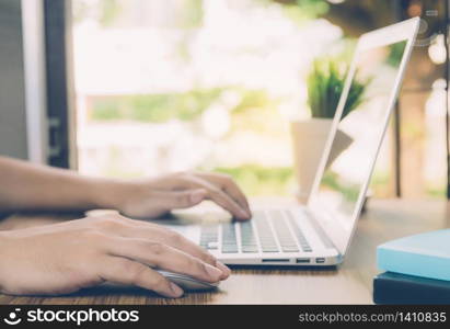 Hand of business man working from home using laptop computer to internet online on desk, lifestyle of new normal, social distancing, freelance work in stay home, employee using notebook indoor.