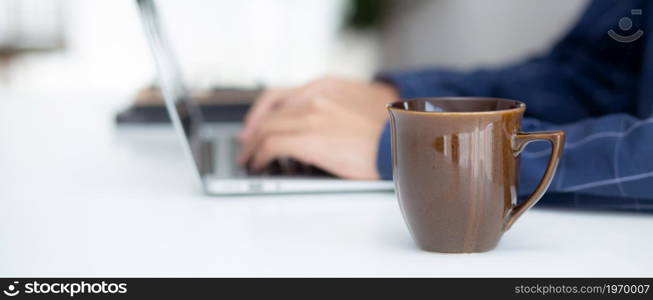 Hand of business man working from home using laptop computer to internet online on desk, lifestyle of new normal, social distancing, freelance work in stay home, employee using notebook indoor.