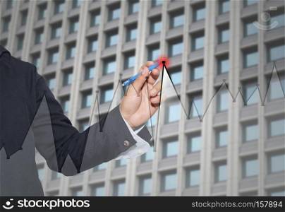 Hand of businessman drawing graphics a top point growing graph to concept of profit in business and have skyscraper background.