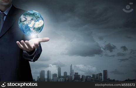 Hand of businessman holding earth planet. Elements of this image are furnished by NASA. World in hands