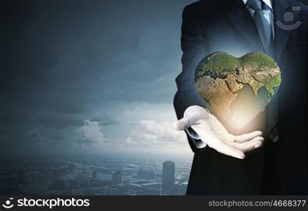 Hand of businessman holding earth planet. Elements of this image are furnished by NASA. Treat our planet with love