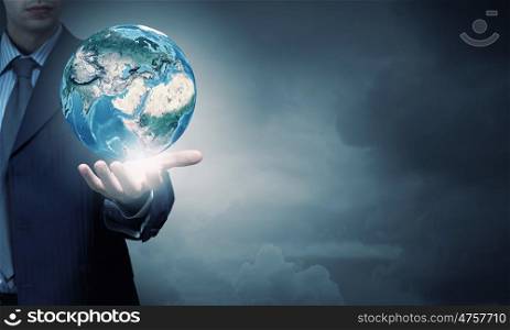 Hand of businessman holding earth planet. Elements of this image are furnished by NASA. World in hands