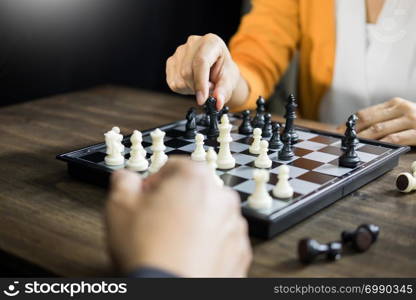 hand of businessman moving chess figure in competition board game for development analysis, strategy idea management or leadership concept