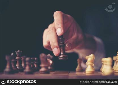 hand of businessman moving chess figure in competition success play. strategy, management or leadership concept