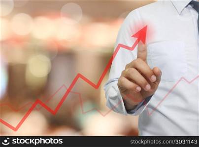 hand of businessman use finger to touch top red arrow.. hand of businessman use finger to touch top red arrow in concept of profit and investment in business.