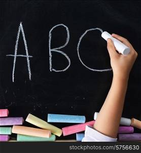 hand of child writing on blackboard