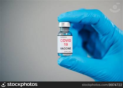 hand of doctor holding Coronavirus  Covid-19  vaccine bottle for injection medicine