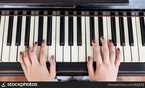 Hand of girl playing piano
