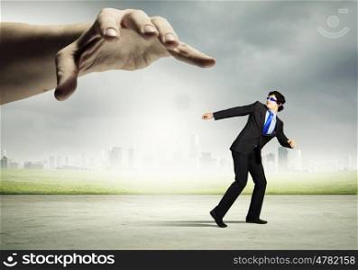 Hand of justice. funny image of businessman trying to run away from hand