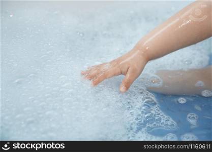 Hand of kid in the bath. Close-up horizontal photo