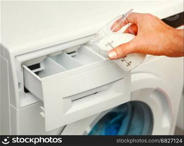 hand of man that fills detergent in the washing machine