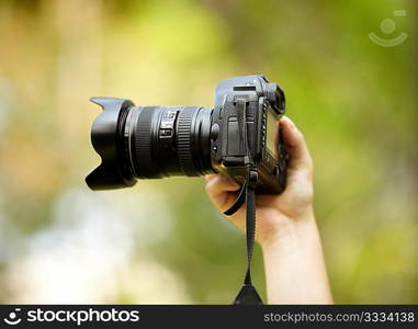 hand of man with black professional camera, natural light, selective focus on nearest part