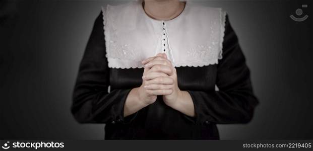 hand of nun praying on black background