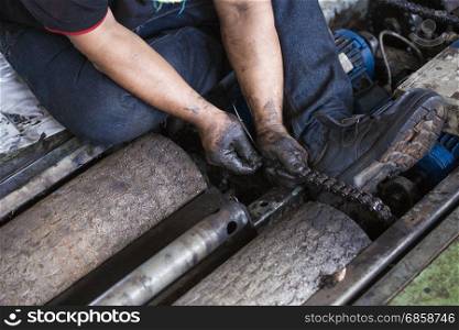 Hand of repairman during maintenance work of chain