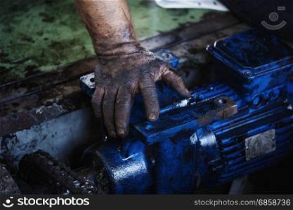 hand of repairman during maintenance work of the electric motor