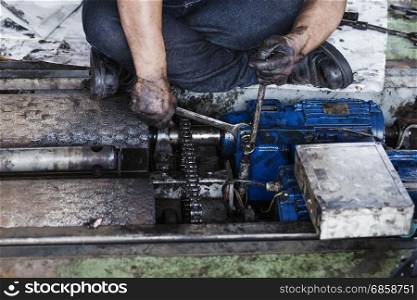 Hand of repairman holding a wrench and tighten and during maintenance work of electric motor