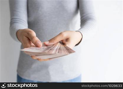 hand of woman counting money on white background. Money baht of thailand in her hand.