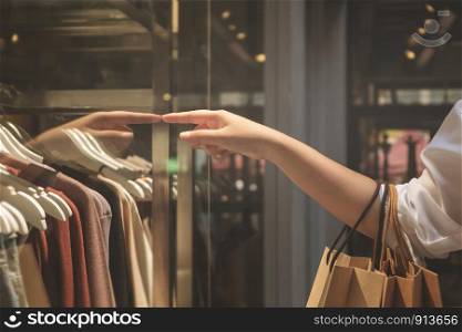 Hand of woman holding paper bags enjoy with shopping in the mall.