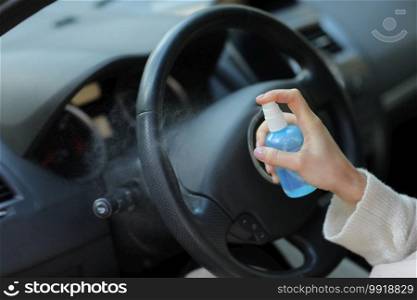 Hand of woman is spraying alcohol,disinfectant spray in car,safety,prevent infection of Covid 19 virus,coronavirus, contamination of germs or bacteria.Alcohol Sanitizer,Hygiene concept. Hand of woman is spraying alcohol,disinfectant spray in car,safety,prevent infection of Covid 19 virus,coronavirus, contamination of germs or bacteria.Alcohol Sanitizer,Hygiene concept.