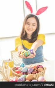 Hand of young beauty woman holding homemade colorful painted Easter egg gift for seasonal and cerebration.