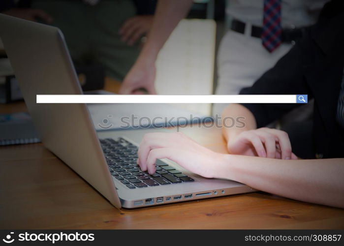 Hand of young business woman typing using laptop computer digital information with blank search bar.