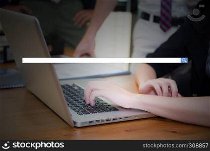Hand of young business woman typing using laptop computer digital information with blank search bar.