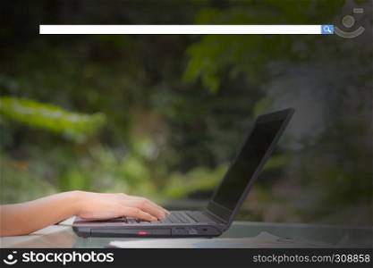 Hand of young business woman typing using laptop computer digital information with blank search bar.