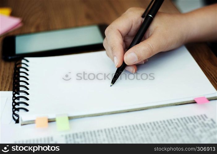 hand of young woman drawing on notebook.