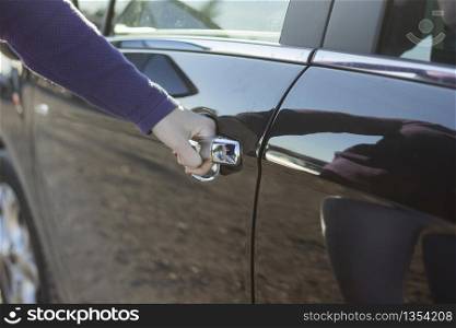Hand on handle. Close-up of woman hand opening a car door.