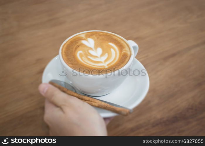 Hand On Hot Cup Of Coffee Latte, stock photo